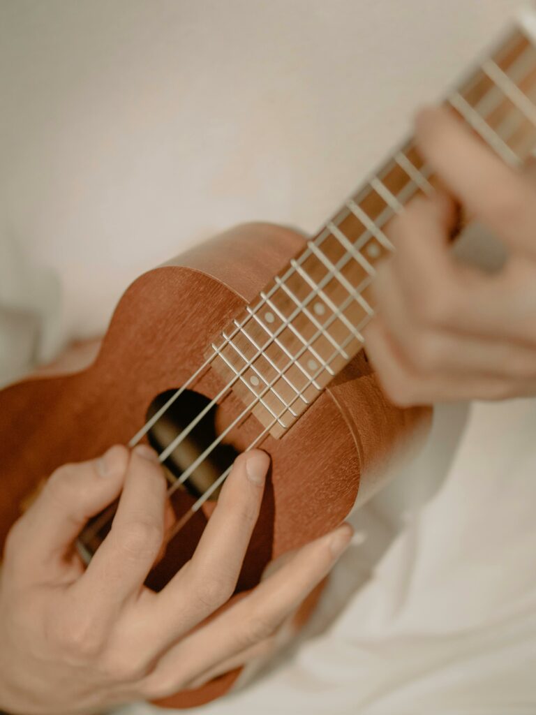 A musician plays ukulele at home, close-up view, creating a calm and cozy atmosphere.